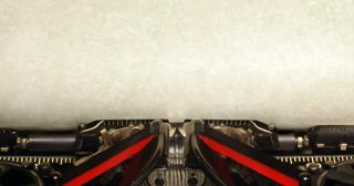 Old vintage typewriter with blank paper